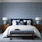 A serene bedroom with a calming blue accent wall featuring a stenciledfeat