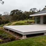 Modern home with a seamlessly integrated deck, demonstrating harmonious architectural flow within the landscape.