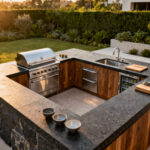 A modern outdoor kitchen layout demonstrating the 'work triangle' flow, connecting the built-in grill, deep sink, and under-counter refrigerator zones for optimal organization and efficiency.