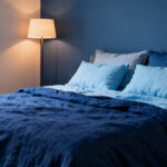 Bedroom with sapphire blue bedding and accent wall, demonstrating psychological impact of blue on serenity.