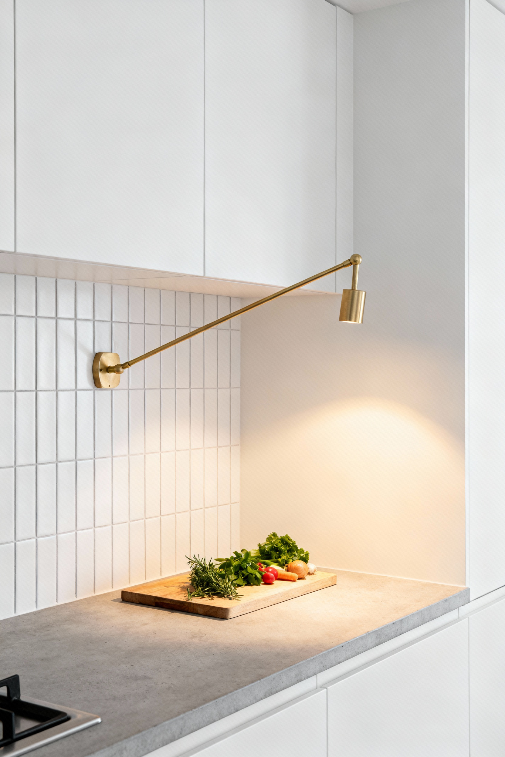 A modern small kitchen countertop featuring an extended swing-arm wall sconce casting focused task lighting onto a wooden cutting board, illustrating how wall-mounted fixtures free up valuable counter space.