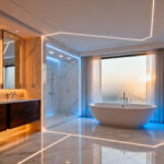 Wide-angle photograph of a luxury modern bathroom divided conceptually into three strategic activity zones (Vanity Zone, Wet Zone, Toilet Zone) using subtle architectural lighting markers on the floor.