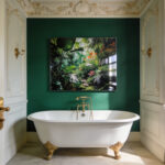 A modern luxury bathroom with a Victorian clawfoot tub and a waterproof metal art print on an emerald green wall.
